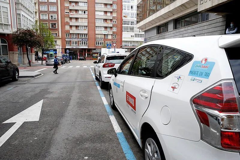 Taxis blancos aparcados en fila en una parada de una calle de Santander