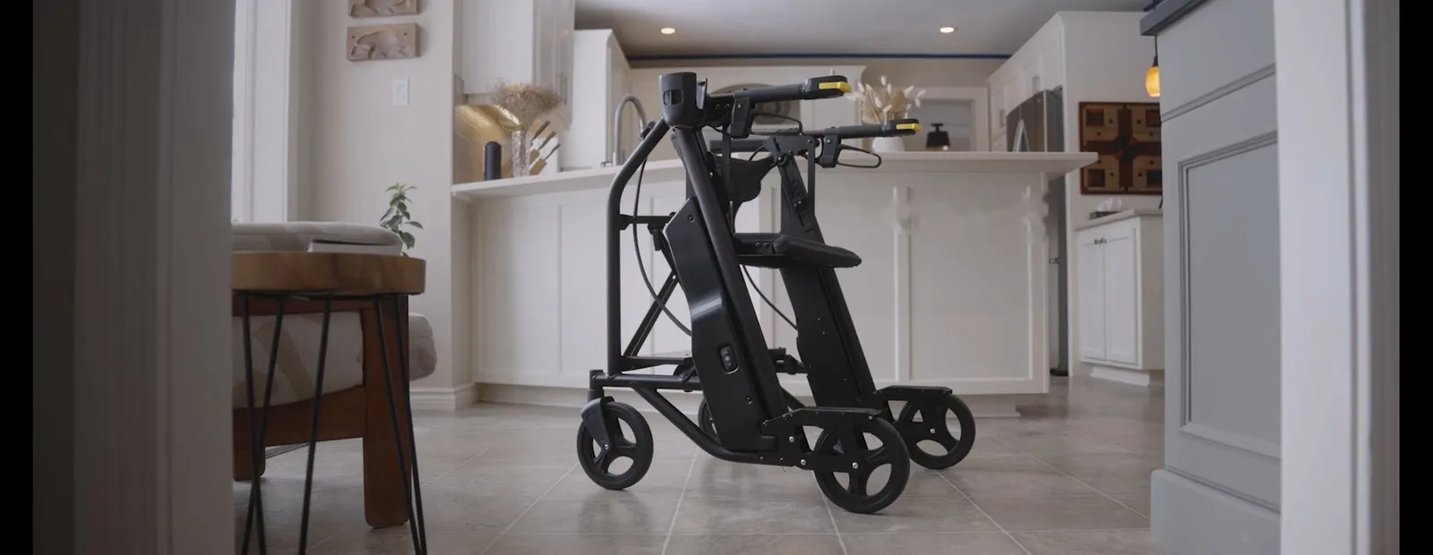 El andador elevador Raymex Lift, de color negro, en la cocina de una vivienda